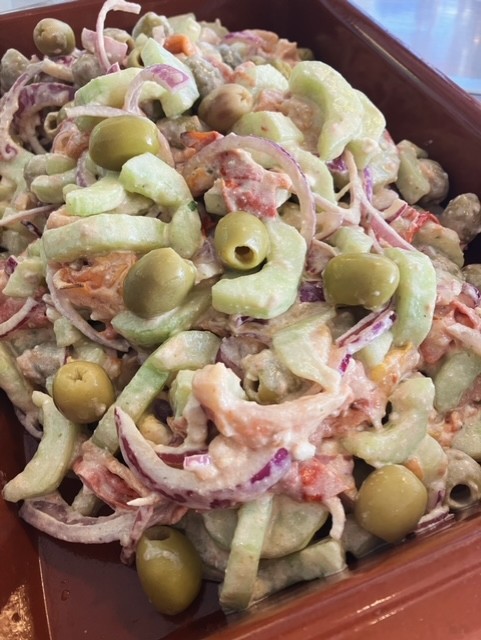 Frisse Griekse salade met geroosterde tomaat, olijf, rode ui, komkommer, feta en een romige basilicum-dressing