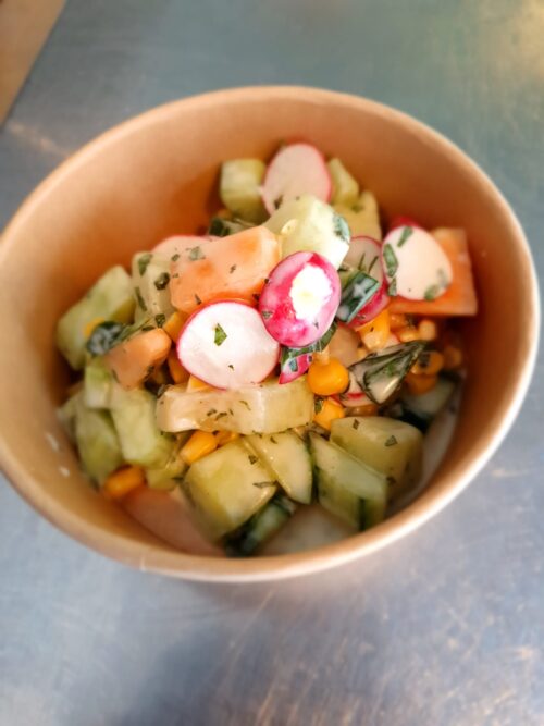 Zomersalade met meloen, komkommer, mais, basilicum, munt en limoen yoghurt dressing