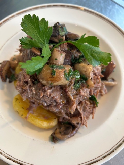 Frans stoofpotje van rund en spek in rode wijn gestoofd, lekker met aardappeltjes uit de oven en in knoflook gebakken paddenstoelen