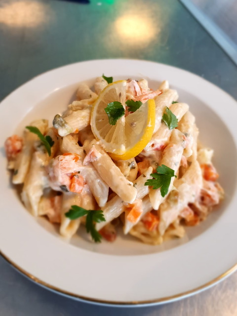 Penne met gerookte zalm en groentes in een romige saus