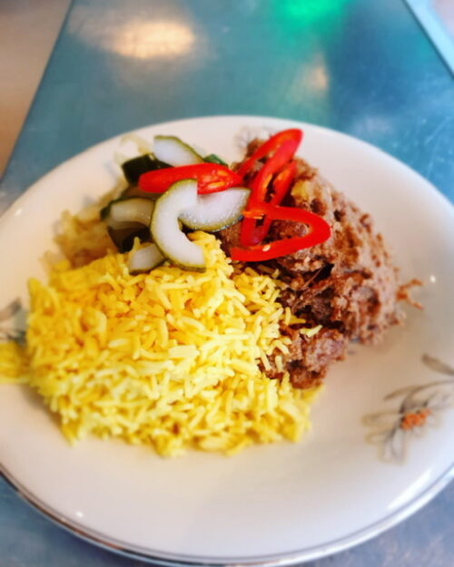 Indonesische rendang van rund met geroosterde groeten en witte rijst