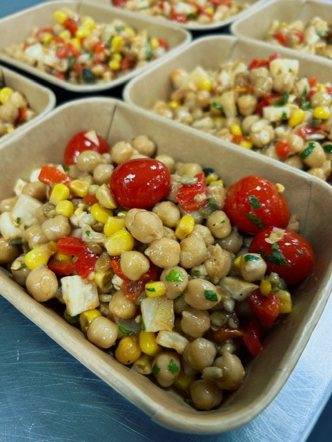 Gezonde kikkererwt-groene linzen salade met mais, geroosterde paprika en limoen vinaigrette