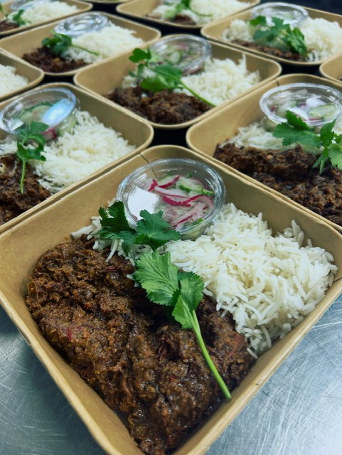 Indonesische rendang van rund met witte rijst en komkommer en rode ui op het zuur