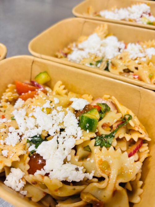 Mediterraanse pastasalade met zongedroogde tomaat, olijf, komkommer, tomaat en feta