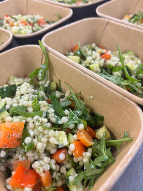 Parelcouscoussalade met geroosterde courgette, paprika, rucola en Parmezaan