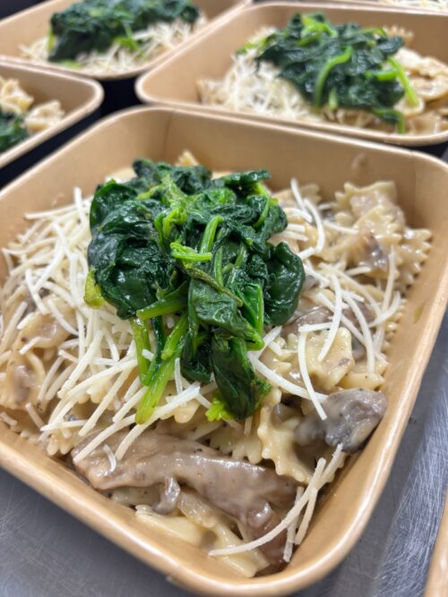 Farfalle met romige paddenstoelensaus, parmezaan en spinazie