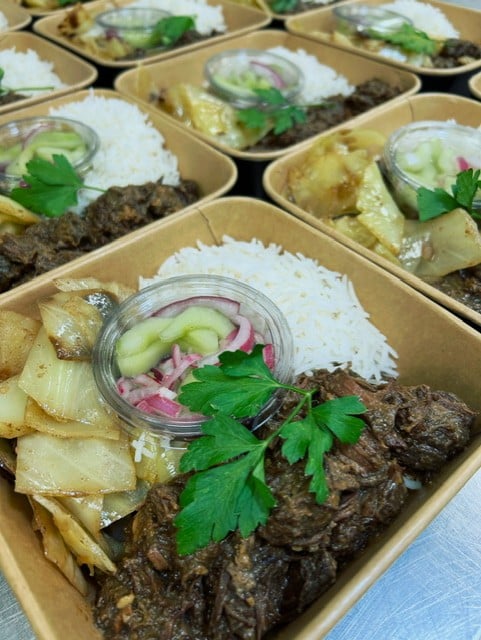 Heerlijke rendang van rund met in garam masala geroosterde kool, witte rijst en komkommer en rode ui op het zuur