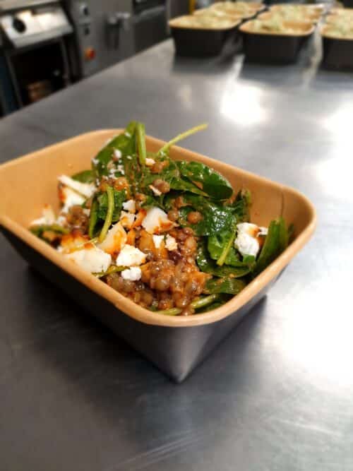 Spinazie salade met linzen, aubergine, gegrilde witte kaas en tomaten vinaigrette
