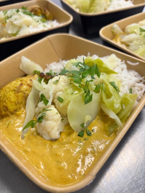 Indiase curry met in yoghurt gemarineerde kipdij met rijst en gesmoorde kool